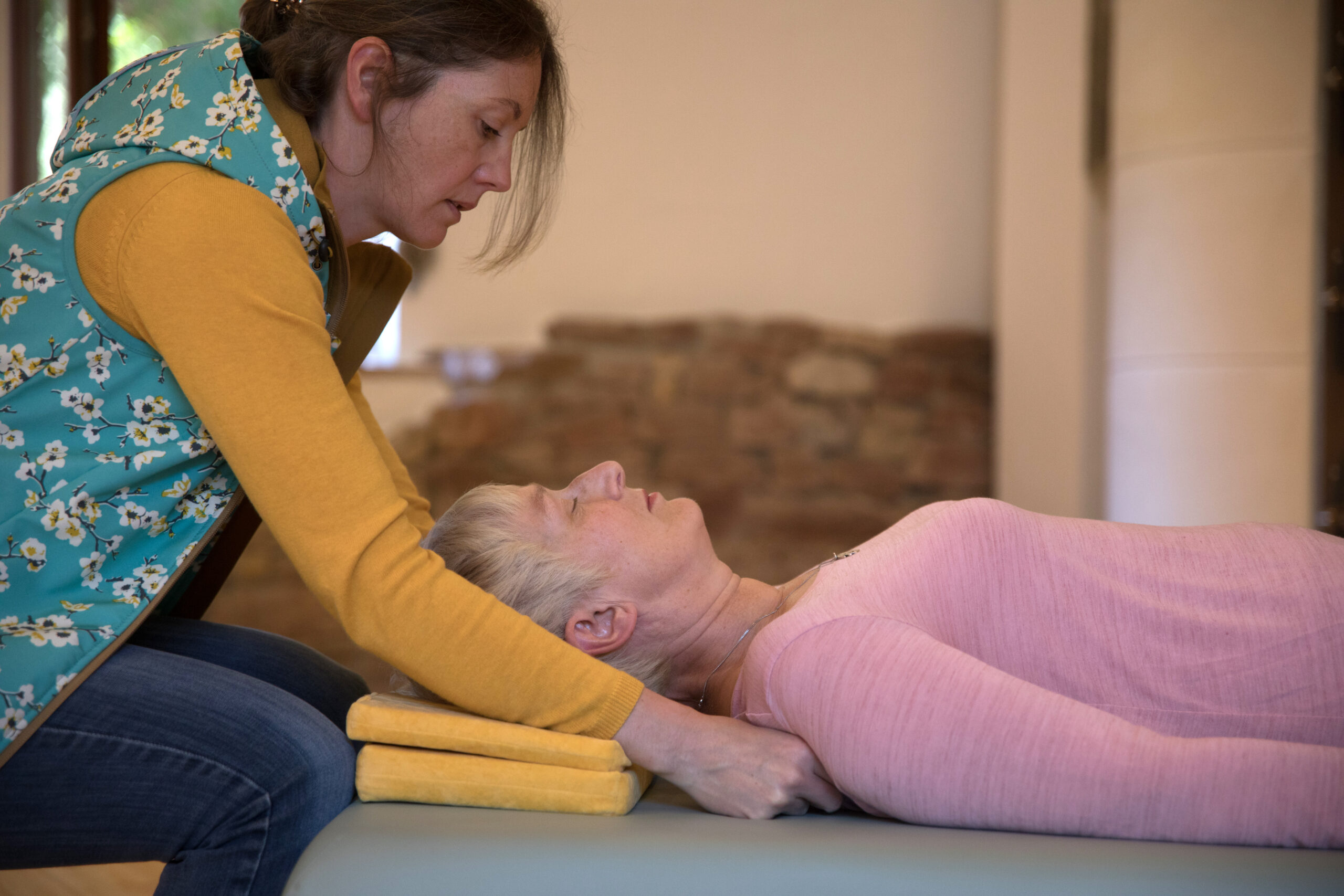 Evelyn Richter arbeitet mit einer Frau auf der Feldenkrais-Liege